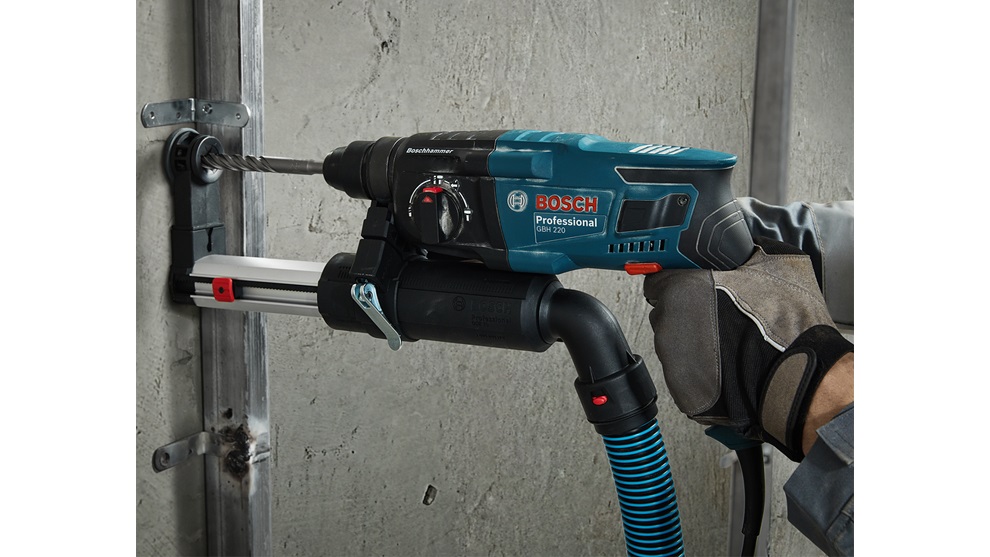 Máy khoan Bosch Professional GBH 220 đang hoạt động trên tường bê tông.
