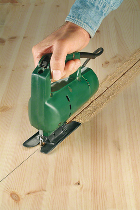 Một người điều khiển máy cưa lọng để cắt một đường thẳng qua một tấm ván gỗ.