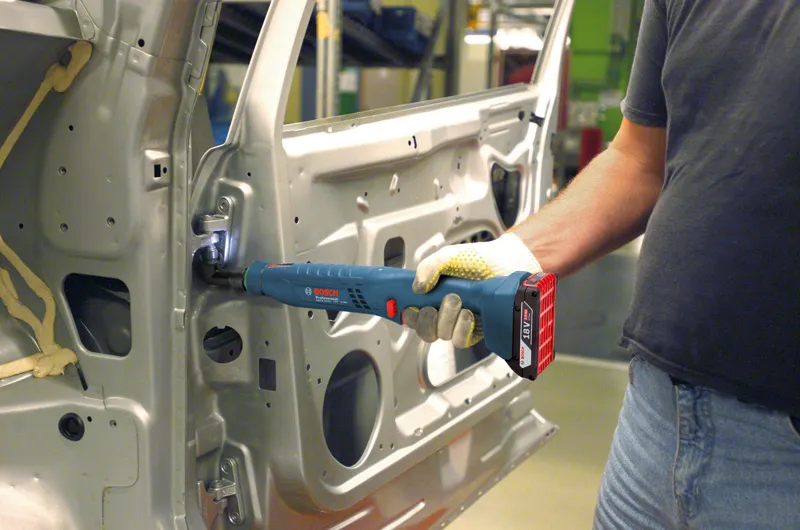 ANGLE EXACT ION 60-120 Người đeo thiết bị an toàn sử dụng một công cụ không dây để siết chặt bản lề bên trong cửa ô tô.