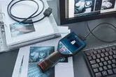 Camera kiểm tra được kết nối với máy tính, cùng với hình ảnh và tài liệu liên quan được đặt trên bàn.