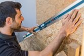 Người sử dụng máy đo độ nghiêng kỹ thuật số để đo góc của bề mặt gỗ.