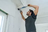 Một người đo góc giữa tường và trần nhà bằng thước đo góc.