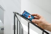 Người sử dụng máy đo laser trên lan can cầu thang kim loại để kiểm tra khoảng cách hoặc góc.
