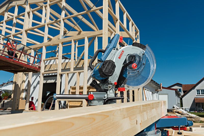 GCM 12 SDE Máy cưa góc trượt được đặt trên dầm gỗ tại công trường xây dựng nhà.