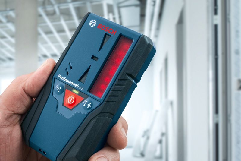 LR 6 Người đang cầm máy thu tia laser trong một tòa nhà đang được xây dựng.