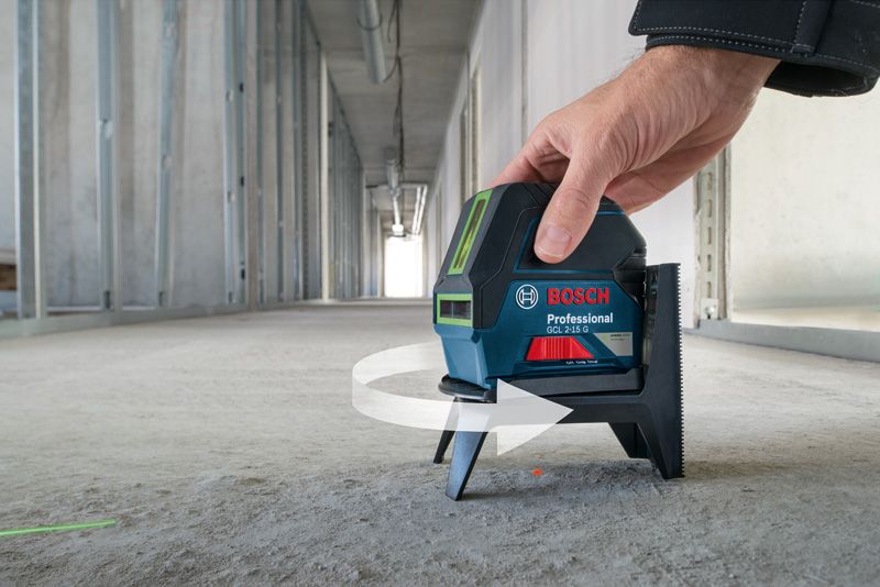 GCL 2-15 G Một người đang điều chỉnh máy cân bằng laser trên sàn bê tông ở hành lang chưa hoàn thiện.