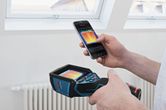 Một người sử dụng camera nhiệt và điện thoại thông minh để xem hình ảnh nhiệt trong nhà.