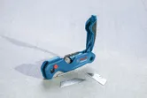 Dao tiện ích có ngăn mở bên cạnh hai lưỡi dao thay thế trên bề mặt màu xám.