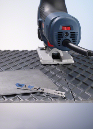 Cắt tấm kim loại bằng máy cưa lọng trên bề mặt có gờ.