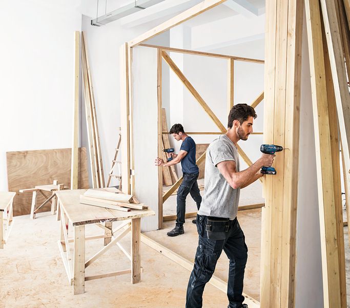 Hai người đàn ông đang xây bức tường gỗ.