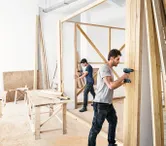 Hai người đàn ông đang xây bức tường gỗ.