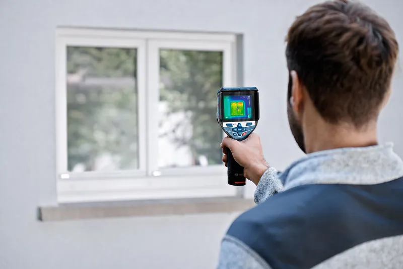GTC 600 C Người sử dụng camera nhiệt để kiểm tra cửa sổ từ bên ngoài tòa nhà.