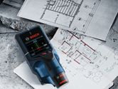 Máy dò kỹ thuật số được đặt trên bản thiết kế kiến trúc để phân tích bố cục tòa nhà.