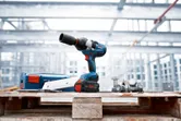 Máy siết bu lông không dây trên pallet gỗ tại một công trường xây dựng.