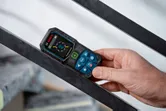 Một người đo góc trên một thanh kim loại bằng thước đo laser.