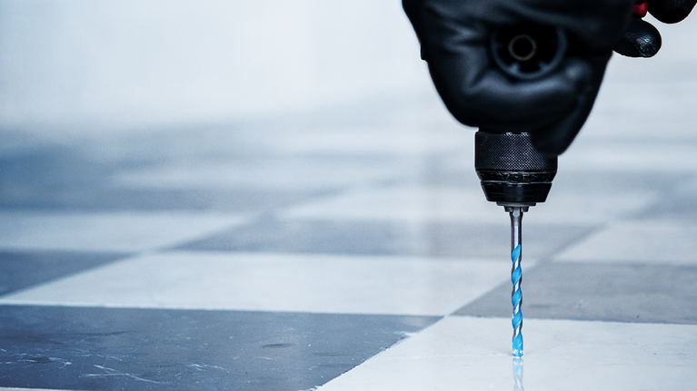 Người đeo thiết bị an toàn khoan vào sàn gạch.