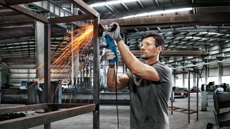 Người đàn ông đang mài khung kim loại.