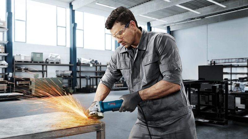 Người đàn ông đang mài bàn kim loại.