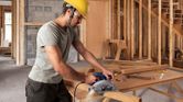 Người đàn ông đang sử dụng máy cưa tròn.