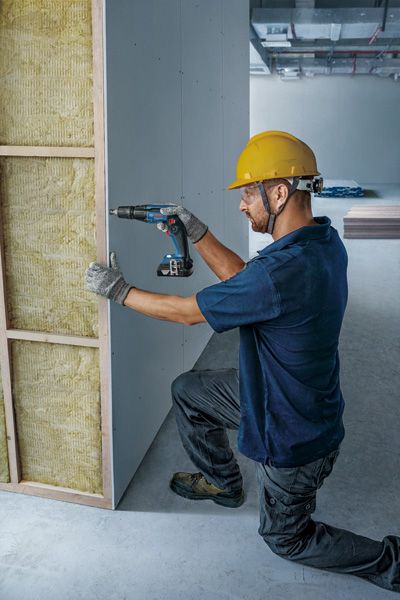 Công nhân đang lắp đặt tấm vách thạch cao.