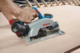 Người này đang sử dụng máy cưa tròn không dây để cắt gỗ tại một công trường xây dựng.