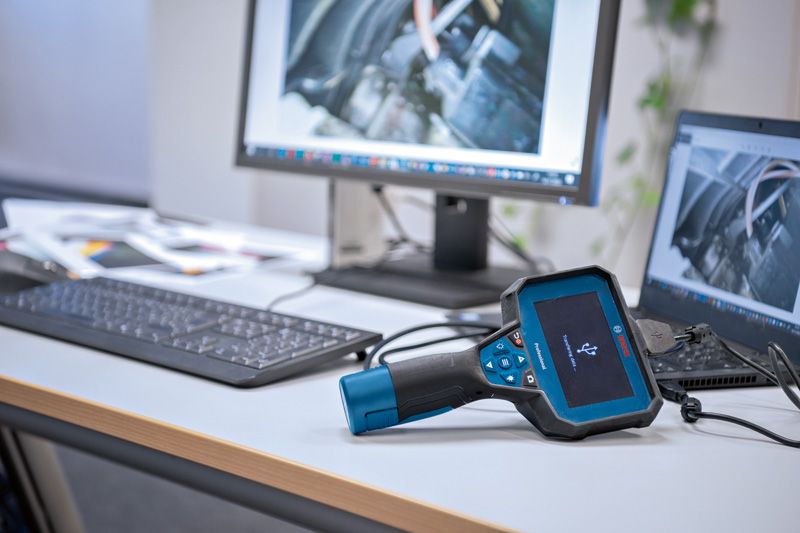 Camera kiểm tra đặt trên bàn, kết nối với máy tính để hiển thị hình ảnh động cơ.