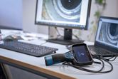 Camera kiểm tra được kết nối với máy tính xách tay trên bàn làm việc với hình ảnh đường ống trên màn hình.