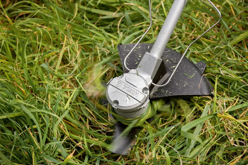 Máy cắt cỏ không dây cắt cỏ cao bằng lưỡi cắt quay.