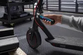 Một người sử dụng tua vít không dây để điều chỉnh tay lái của xe tay ga điện.