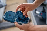Người ta lắp một bộ pin vào hộp đựng dụng cụ điện màu xanh.