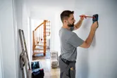 Người đánh dấu bức tường bằng bút chì trong khi sử dụng công cụ dò tìm.