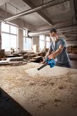 Máy thổi bụi Bosch GBL 650 thổi sạch mùn cưa khỏi bàn làm việc.