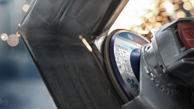 Máy mài góc cắt qua kim loại, tia lửa bắn ra từ điểm tiếp xúc.