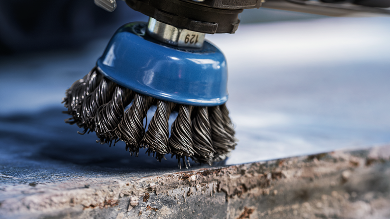 Đầu bàn chải sắt làm sạch rỉ sét trên bề mặt kim loại.