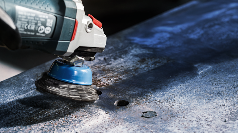 Máy mài chổi cốc kim loại để loại bỏ rỉ sét trên tấm kim loại.