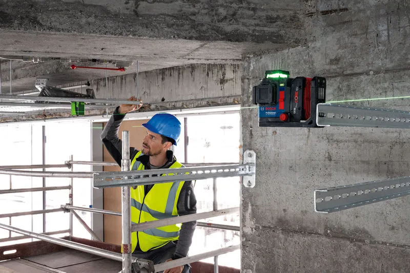 GLL 18V-120-33 CG Một người đeo thiết bị an toàn đang căn chỉnh các thanh kim loại bằng dụng cụ cân bằng laser.