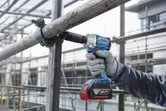 Một người mặc thiết bị an toàn sử dụng cờ lê lực không dây để siết chặt giàn giáo.