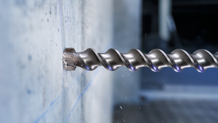 Mũi khoan xoắn lớn khoan vào tường bê tông.