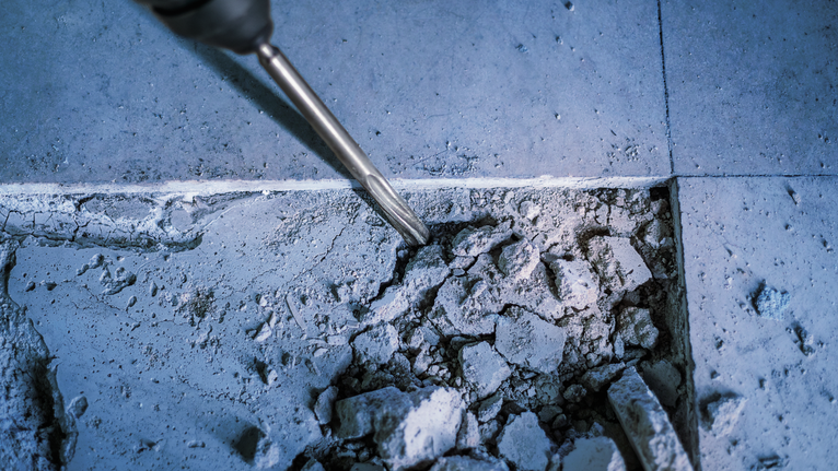 Máy đục búa quay đang đục phá sàn bê tông.