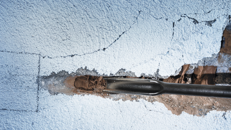 Dụng cụ đục phá vỡ lớp thạch cao trên tường.