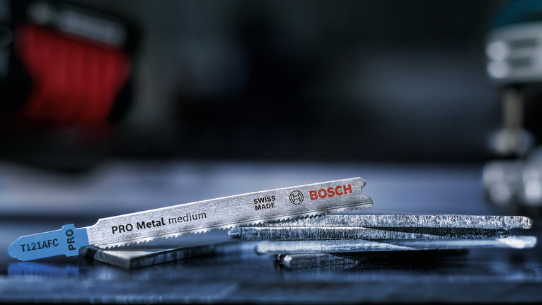 Lưỡi cưa lọng bằng kim loại nằm trên bàn làm việc.