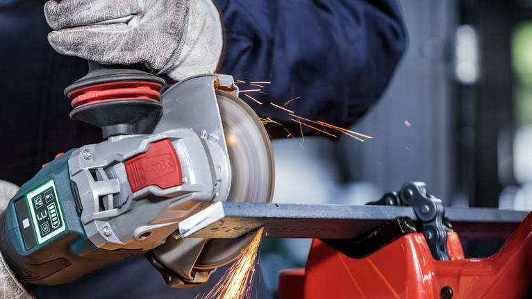 Đá cắt liên kết PRO Metal, 125 x 1,6 x 22,23 mm, X-Lock Một người mặc đồ bảo hộ sẽ mài kim loại bằng máy mài góc, tạo ra tia lửa.