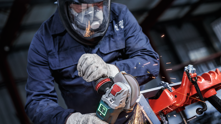 Đá cắt liên kết PRO Metal, 125 x 1,6 x 22,23 mm, X-Lock Một người mặc đồ bảo hộ sẽ mài kim loại, tạo ra tia lửa.