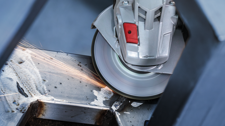 Đĩa mài PRO Stainless Steel, 125 x 6 x 22,23 mm Máy mài góc cắt qua thanh kim loại, tạo ra tia lửa điện.