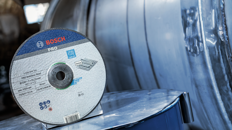 Đĩa mài PRO Stainless Steel, 180 x 6 x 22,23 mm Đĩa cắt thép không gỉ đặt trên bề mặt kim loại phản quang.