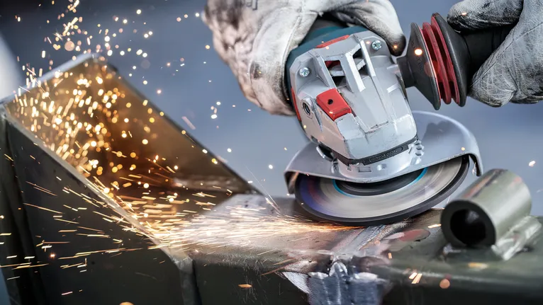 Người đeo thiết bị an toàn mài kim loại, tạo ra tia lửa sáng.