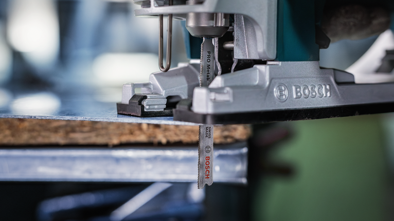 Máy cưa lọng đang cắt một miếng gỗ trên bàn làm việc.