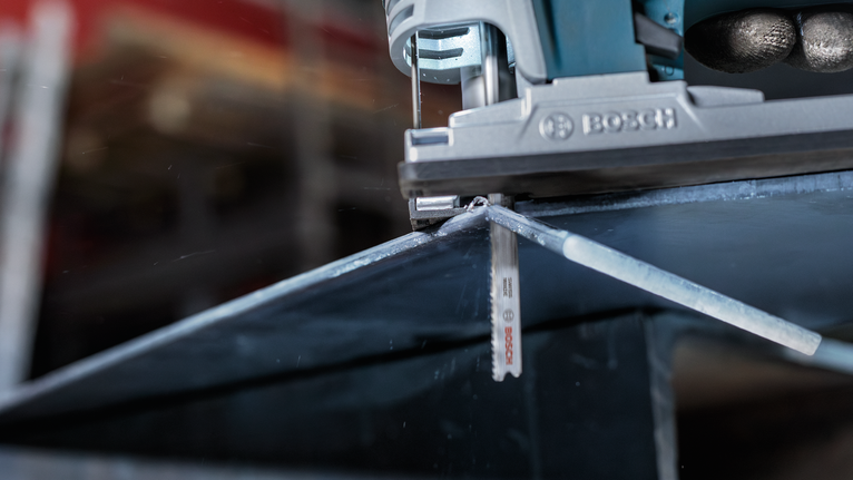 Máy cưa lọng cắt tấm kim loại theo đường đã đánh dấu.