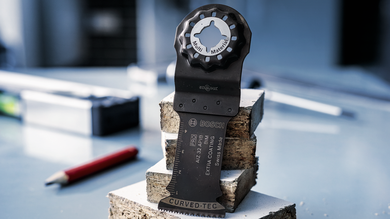 Lưỡi cưa dao động đứng thẳng trên các khối bê tông xếp chồng trong một xưởng.