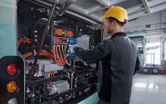 Một người mặc đồ bảo hộ đang sử dụng cờ lê lực không dây trên xe buýt điện.